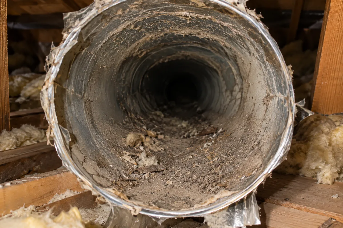 Crushed and disconnected ducting in a roof space before repair